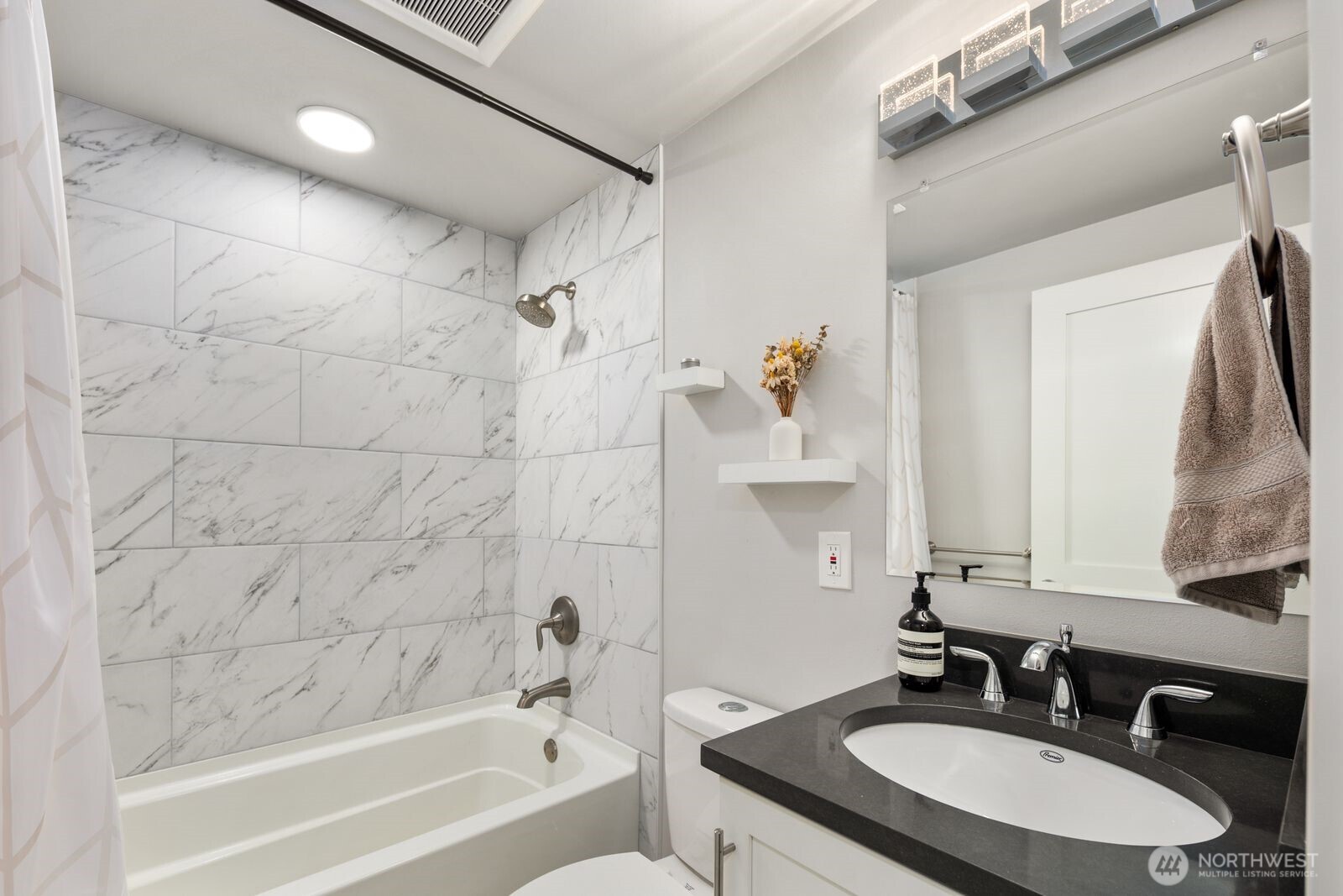 1729 18th Avenue, Unit 201 Seattle, WA 98122 - Photo 16 of 31 a bathroom with a granite countertop sink a mirror a bathtub and a shower