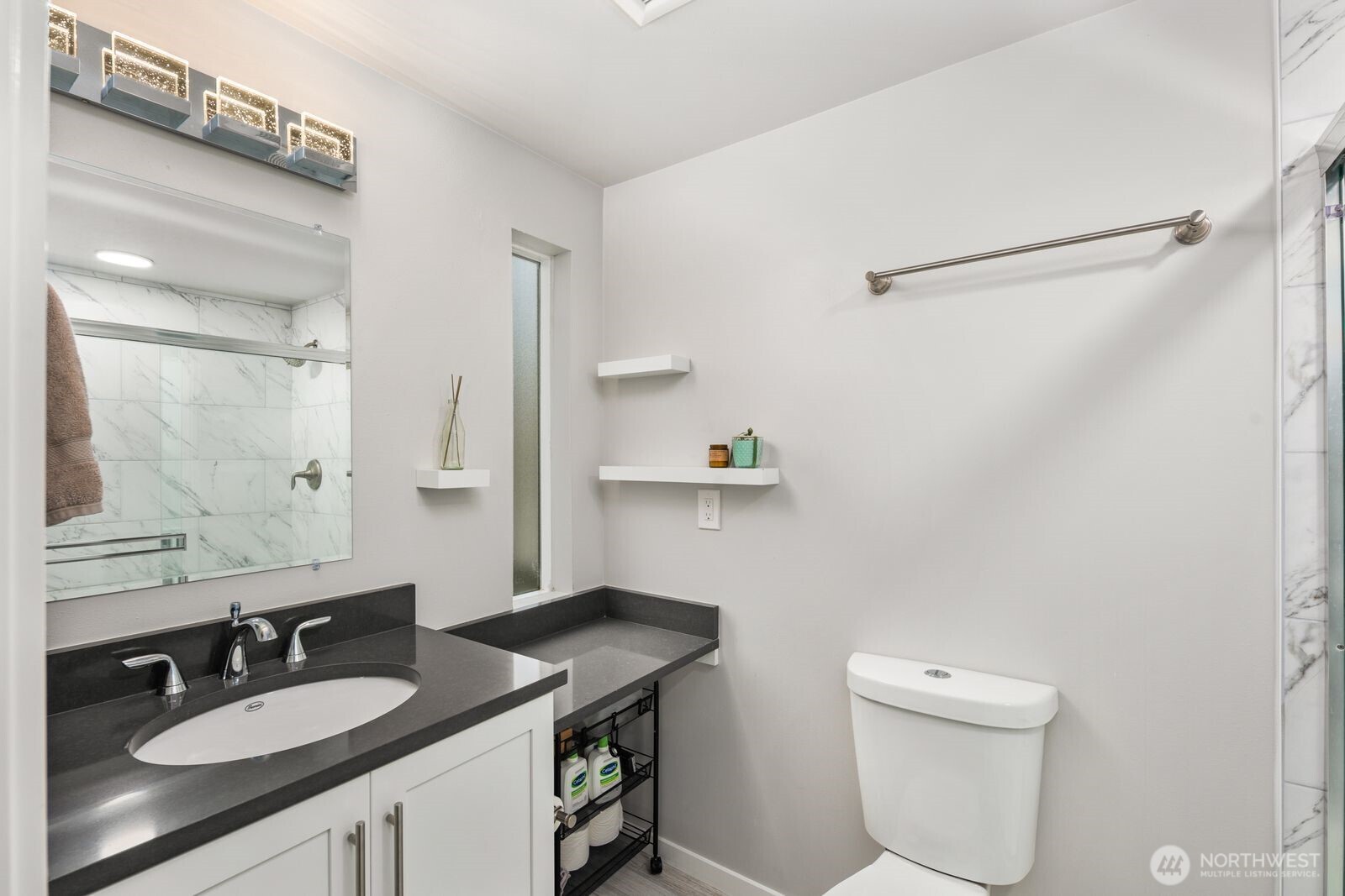 1729 18th Avenue, Unit 201 Seattle, WA 98122 - Photo 23 of 31 a bathroom with a granite countertop sink a toilet a mirror and shower