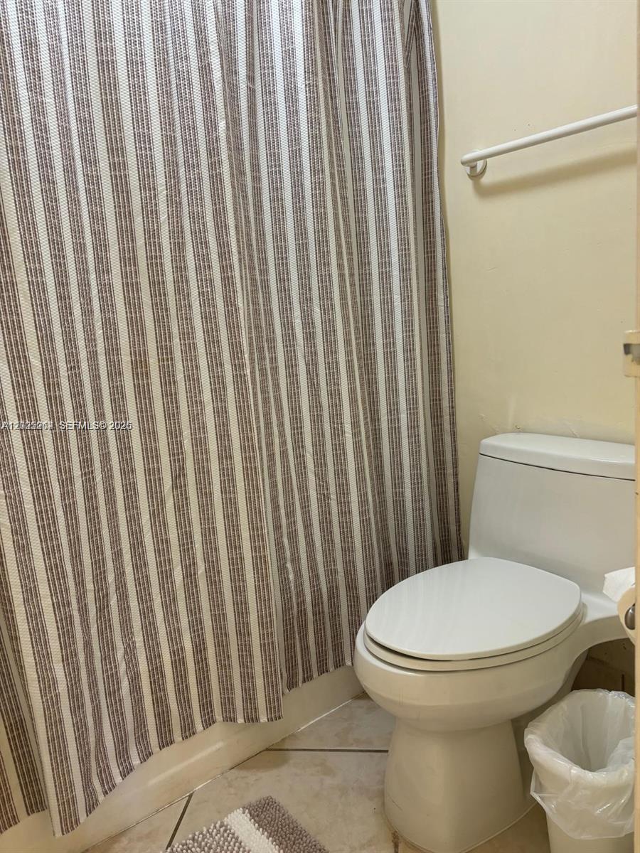 100 Lincoln Road, Unit 731 Miami Beach, FL 33139 - Photo 13 of 14 a white toilet sitting next to a shower curtain