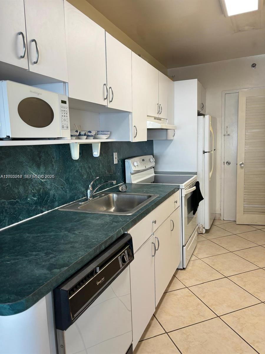 100 Lincoln Road, Unit 731 Miami Beach, FL 33139 - Photo 7 of 14 a kitchen with granite countertop a sink a stove and cabinets