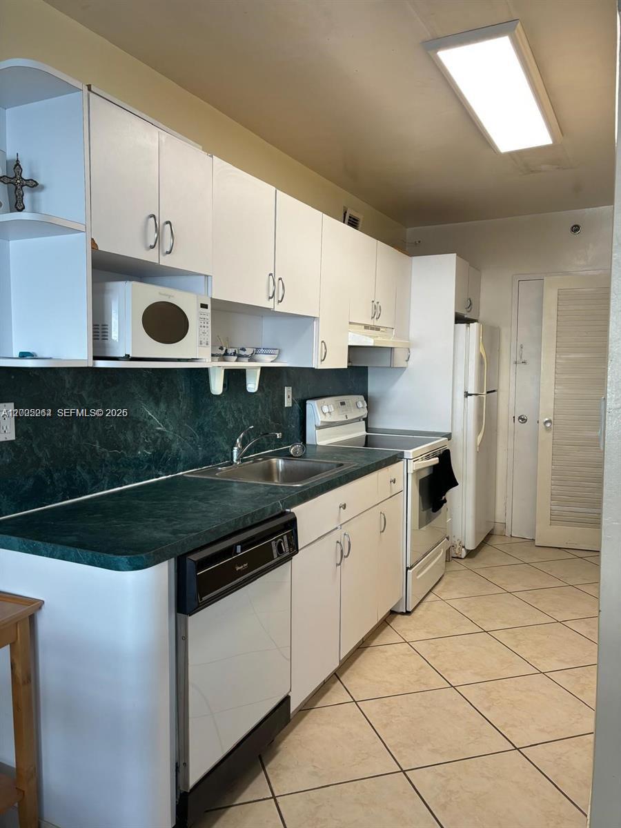 100 Lincoln Road, Unit 731 Miami Beach, FL 33139 - Photo 8 of 14 a kitchen with stainless steel appliances granite countertop a sink and cabinets