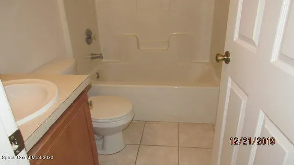 a white toilet sitting next to a bath tub