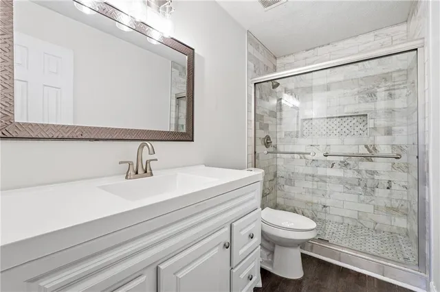 a bathroom with a sink a toilet and shower