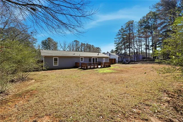 a front view of house with yard and trees in the background