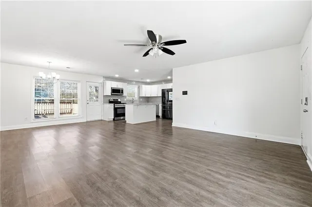 a view of a kitchen with a fridge wooden floor and a window