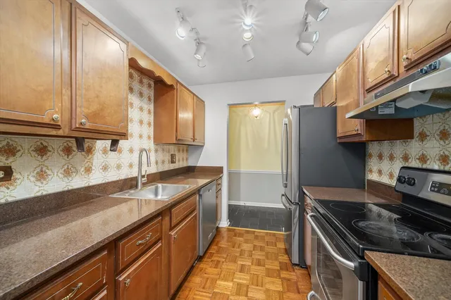 a kitchen with stainless steel appliances granite countertop a sink stove and refrigerator