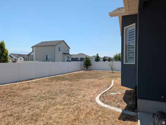 171 South Mustang Road East Grantsville, UT 84029 - Photo 39 of 41 Spacious backyard area featuring a white vinyl fence and a curved concrete border