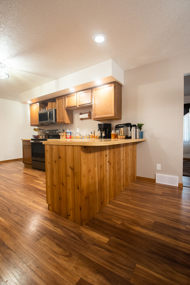 2235 Center Lane Dixon, IL 61021 - Photo 13 of 51 a kitchen with wooden floors and wooden cabinets