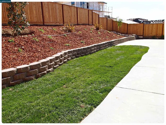 a view of a backyard with wooden fence