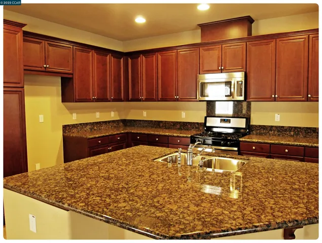 a kitchen with a refrigerator and a stove top oven