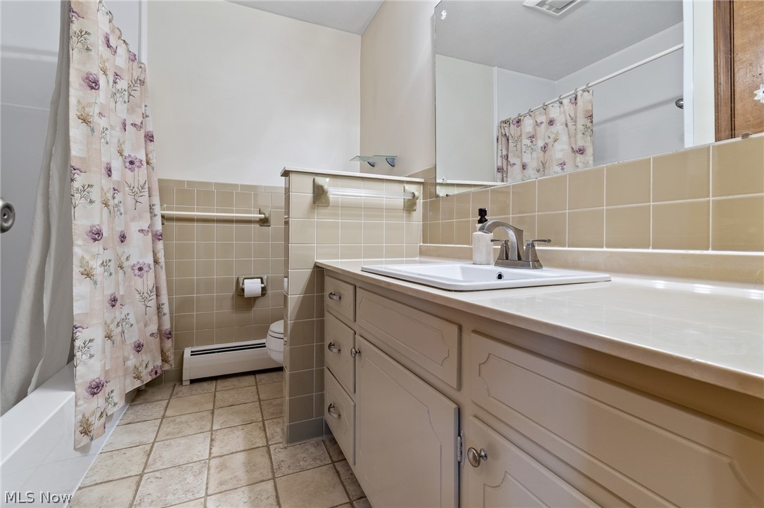 34 Kehner Road Mogadore, OH 44260 - Photo 23 of 40 Vanity with integrated sink, a large wall-mounted mirror, and tile flooring
