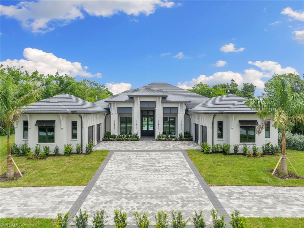 209 Tupelo Road Naples, FL 34108 - Photo 13 of 49 a front view of a house with a yard and potted plants