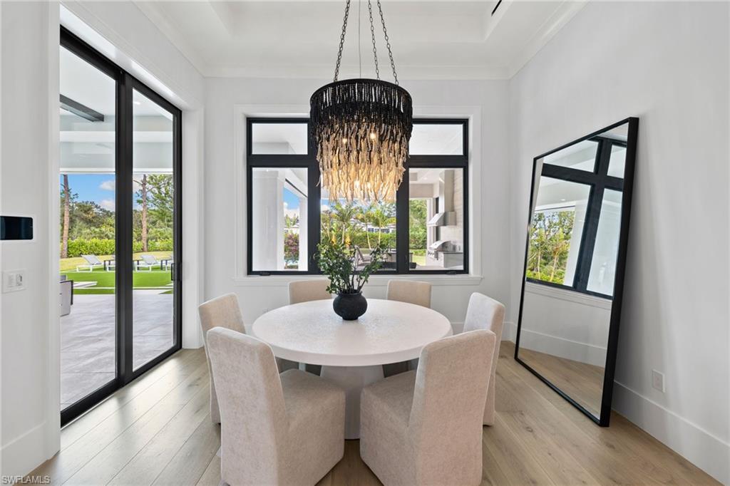 209 Tupelo Road Naples, FL 34108 - Photo 15 of 49 Dining room with a chandelier, crown molding, and light hardwood / wood-style flooring