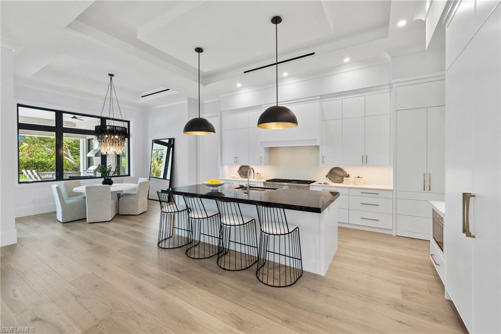209 Tupelo Road Naples, FL 34108 - Photo 23 of 49 a kitchen with stainless steel appliances a stove a sink a window and chairs