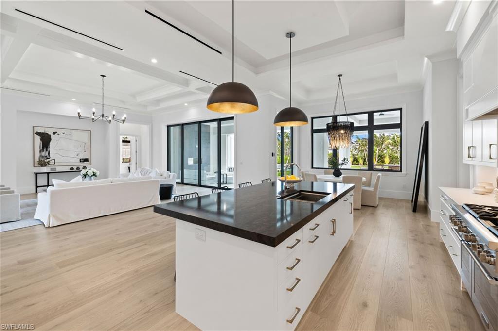 209 Tupelo Road Naples, FL 34108 - Photo 25 of 49 a large kitchen with stainless steel appliances kitchen island granite countertop a large counter top a stove a sink and a wooden floors