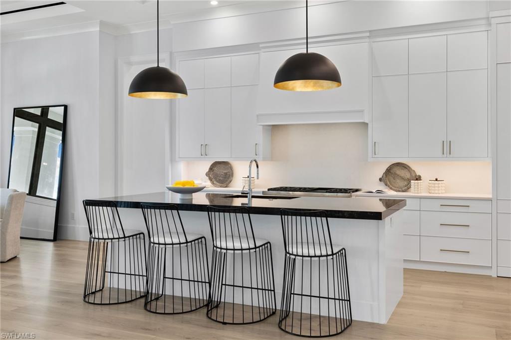 209 Tupelo Road Naples, FL 34108 - Photo 27 of 49 a kitchen with a sink a chandelier and wooden floor