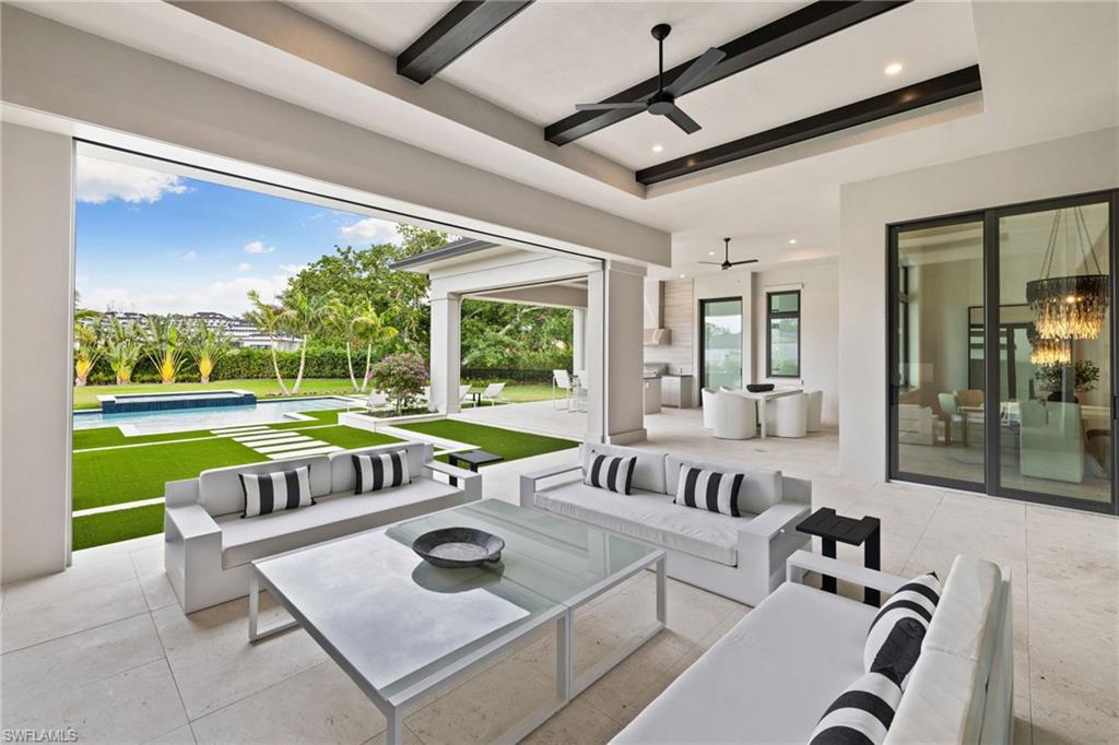 209 Tupelo Road Naples, FL 34108 - Photo 40 of 49 a view of a patio with a table and chairs