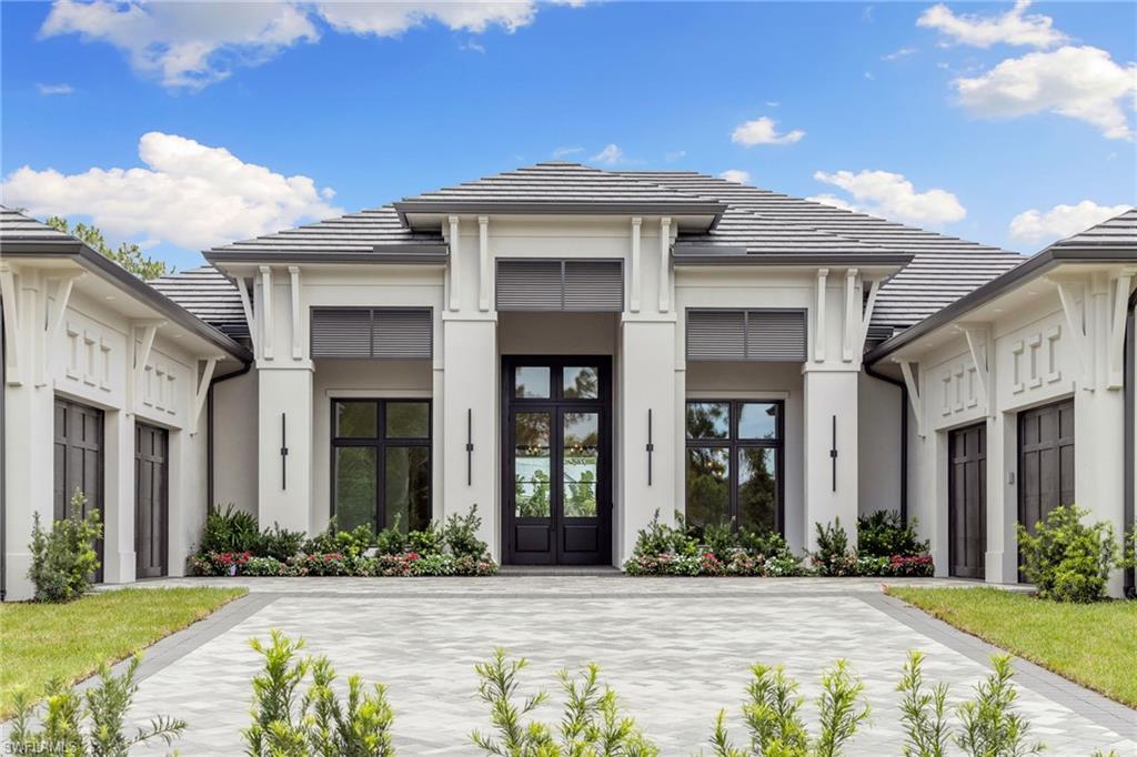 209 Tupelo Road Naples, FL 34108 - Photo 4 of 49 a front view of brick house with a yard