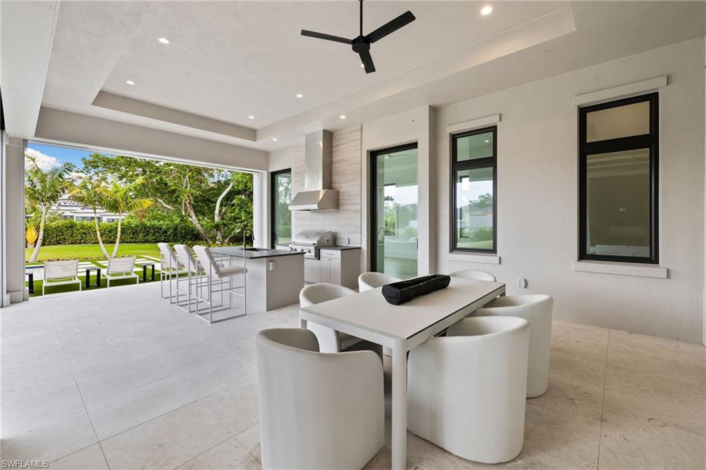 209 Tupelo Road Naples, FL 34108 - Photo 41 of 49 a view of an outdoor dining room and patio with a floor to ceiling window