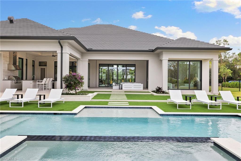 209 Tupelo Road Naples, FL 34108 - Photo 5 of 49 a view of a house with a swimming pool and a large window