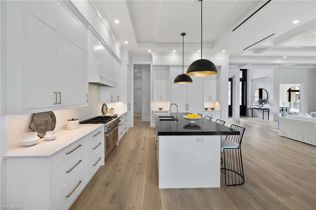 209 Tupelo Road Naples, FL 34108 - Photo 7 of 49 a kitchen with a sink stove and wooden floor