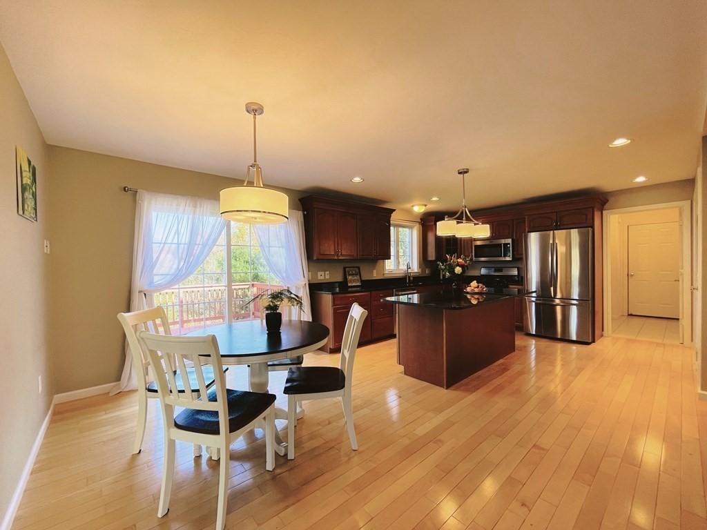 18 Windsor Road Shirley, MA 01464 - Photo 8 of 33 a kitchen with stainless steel appliances kitchen island granite countertop a table chairs and a refrigerator