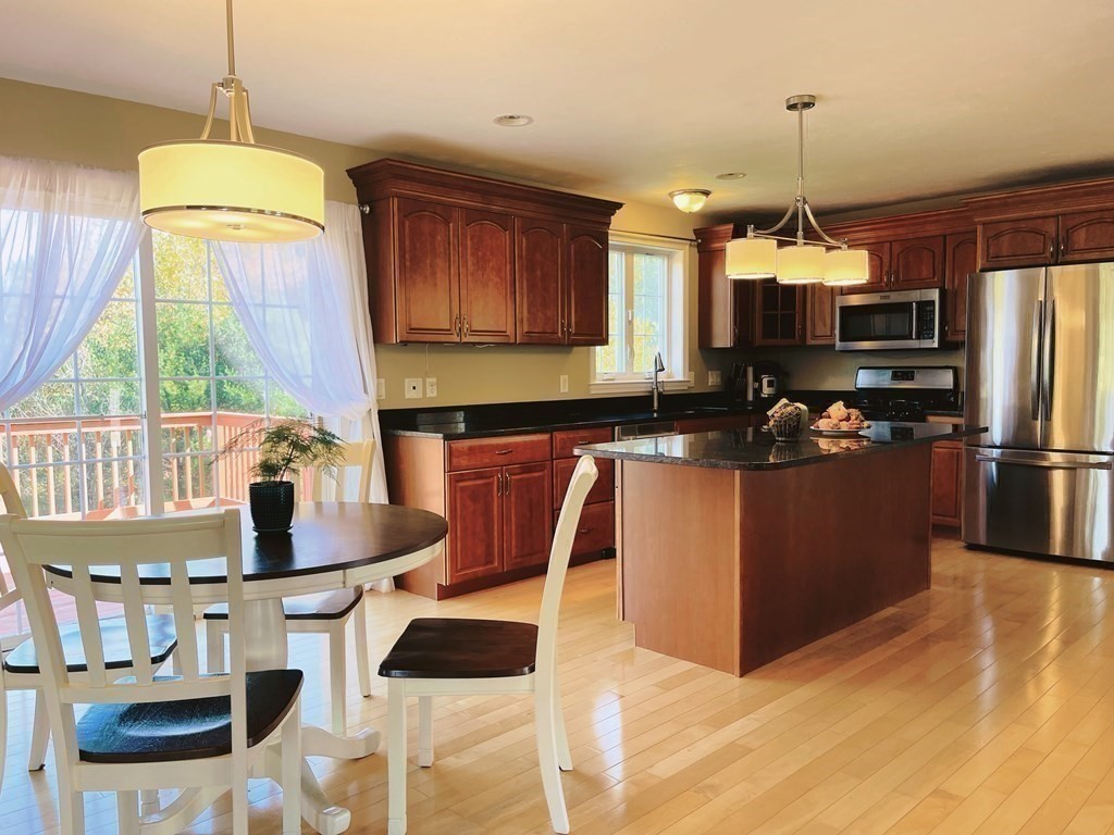 18 Windsor Road Shirley, MA 01464 - Photo 10 of 33 a kitchen with stainless steel appliances a dining table chairs stove refrigerator and cabinets