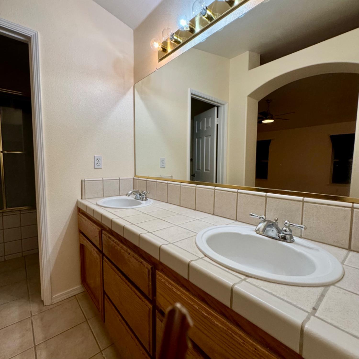 3209 Ren Way Madera, CA 93637 - Photo 13 of 17 a bathroom with a sink and a mirror