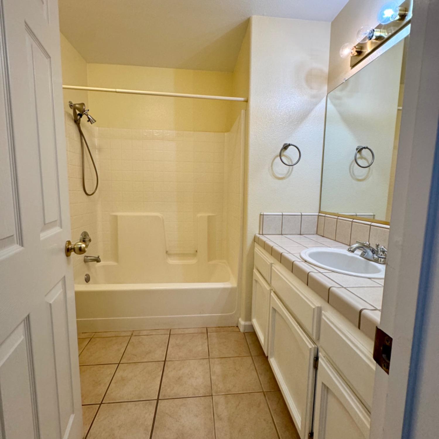 3209 Ren Way Madera, CA 93637 - Photo 15 of 17 a spacious bathroom with a granite countertop sink a toilet and shower