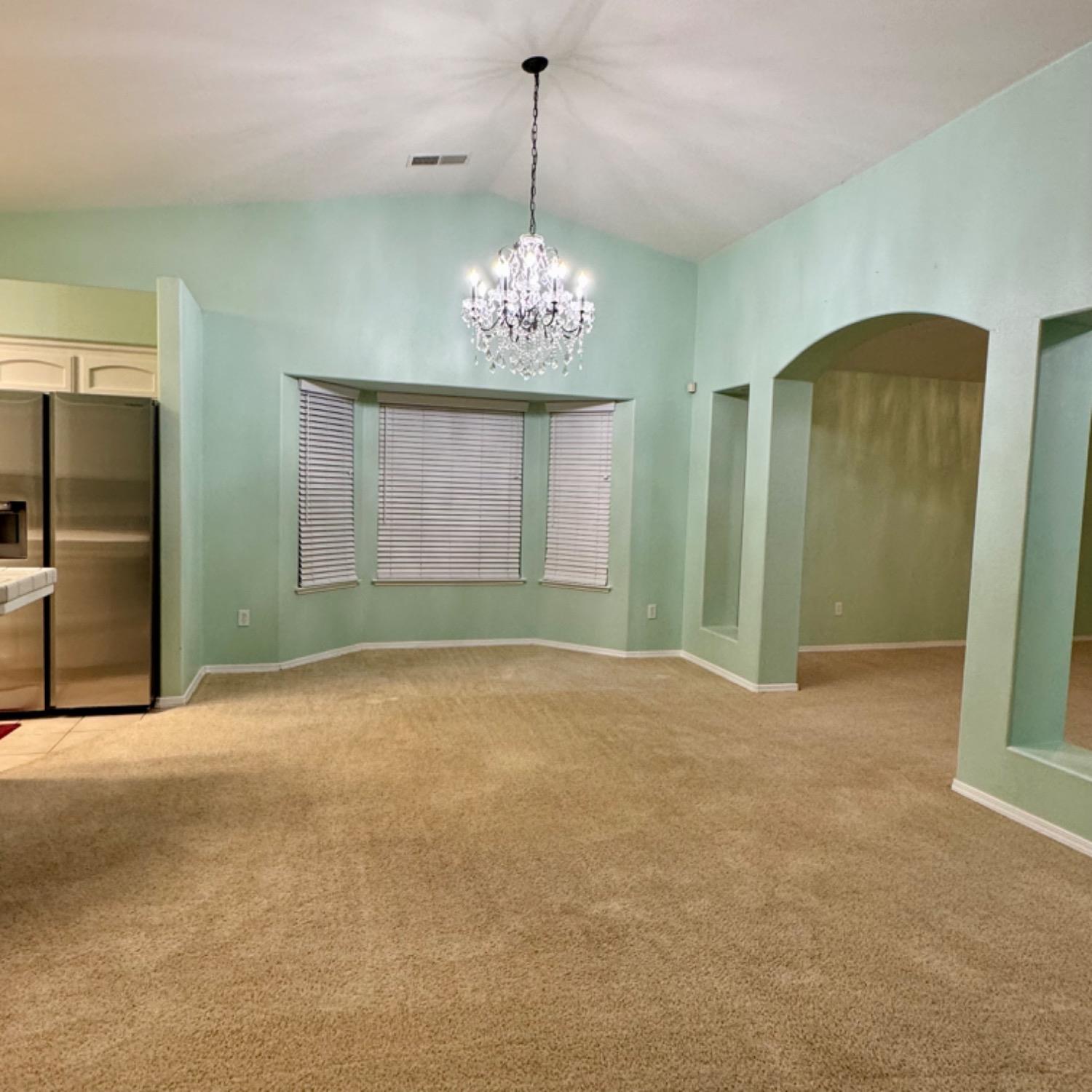 3209 Ren Way Madera, CA 93637 - Photo 4 of 17 a view of an empty room with chandelier and glass door