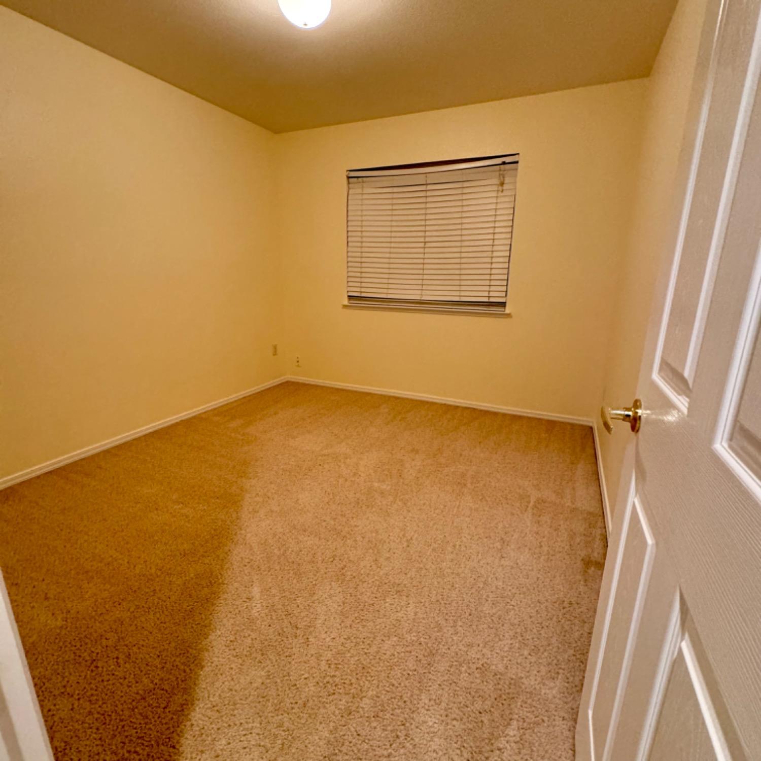 3209 Ren Way Madera, CA 93637 - Photo 10 of 17 an empty room with a wooden door and a window