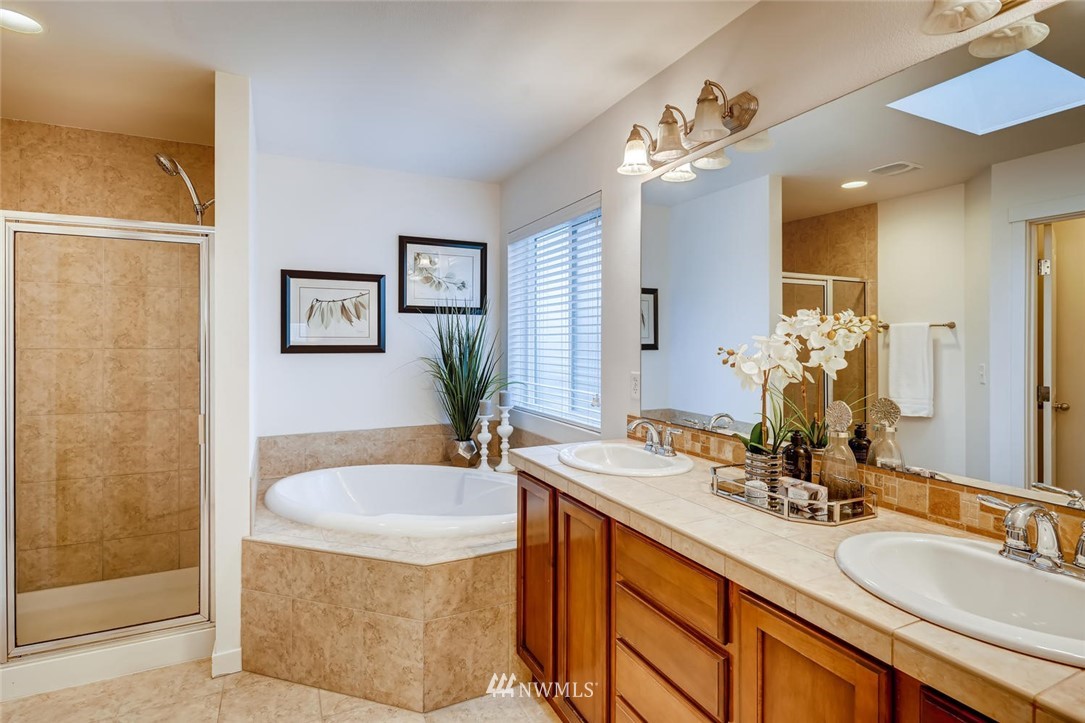 22325 36th Avenue Southeast Bothell, WA 98021 - Photo 14 of 22 a bathroom with a granite countertop sink a large mirror and a shower