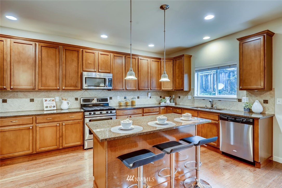 22325 36th Avenue Southeast Bothell, WA 98021 - Photo 8 of 22 a kitchen with stainless steel appliances granite countertop a stove a sink a microwave a center island and cabinets