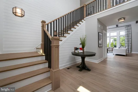 a kitchen with stainless steel appliances a dining table chairs stove and cabinets