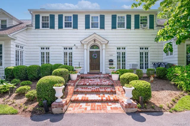 a front view of a house with yard and outdoor seating