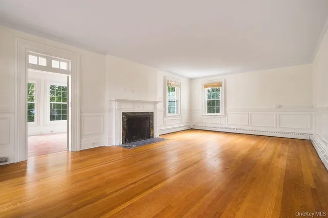 a view of empty room with wooden floor and fireplace