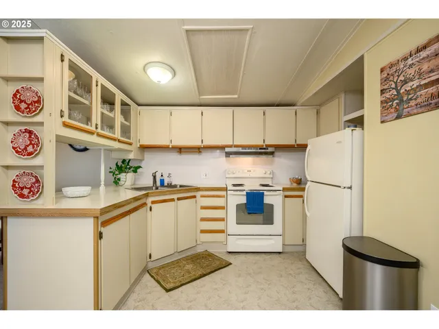 a kitchen with sink cabinets and flat screen tv