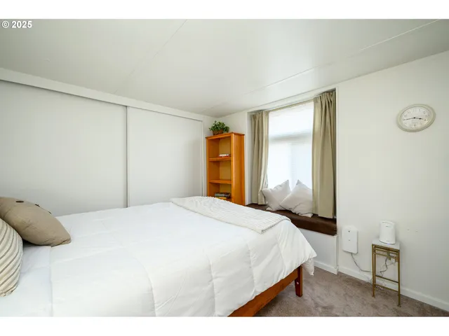 a bedroom with a bed and a large window