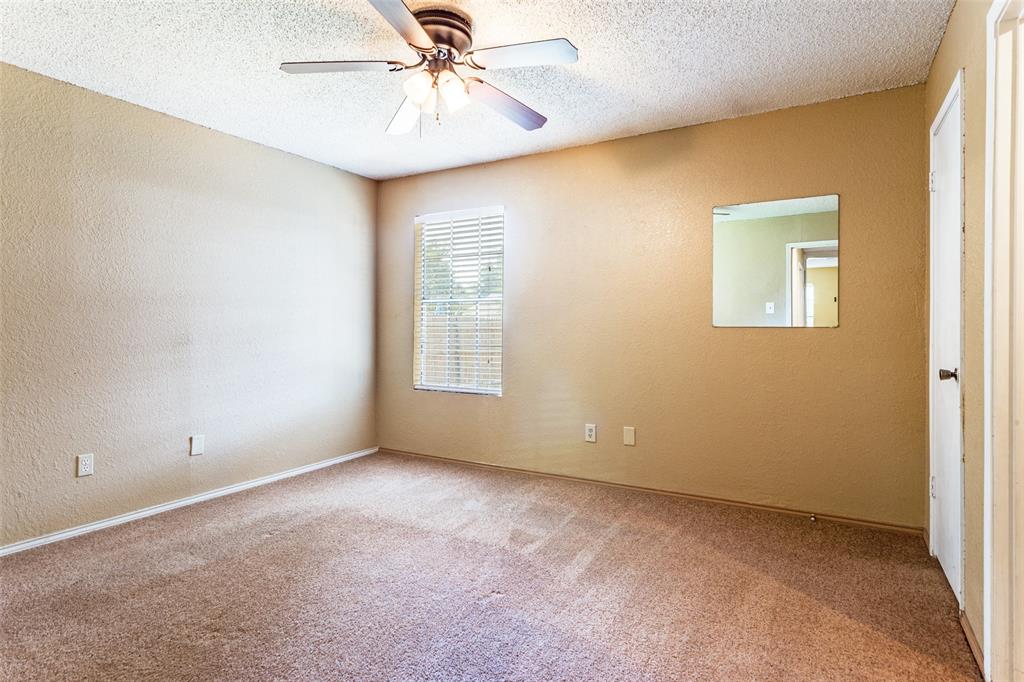 825 Blue Ridge Drive Burleson, TX 76028 - Photo 16 of 25 Spacious primary bedroom featuring carpet flooring, and ceiling fan located at the end of the hall.