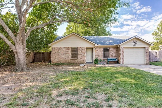 a front view of a house with a garden and trees