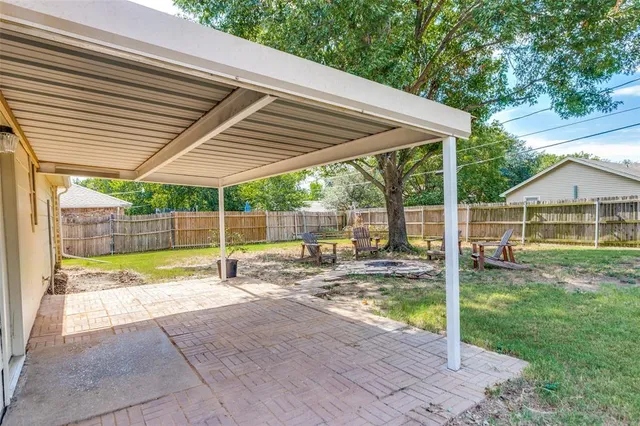 a backyard of a house with table and chairs