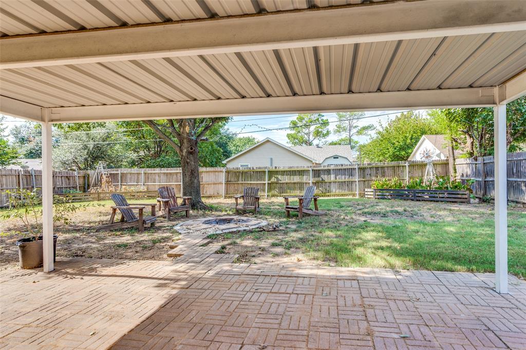 825 Blue Ridge Drive Burleson, TX 76028 - Photo 22 of 25 Spacious fenced in backyard featuring an outdoor fire pit and a patio.