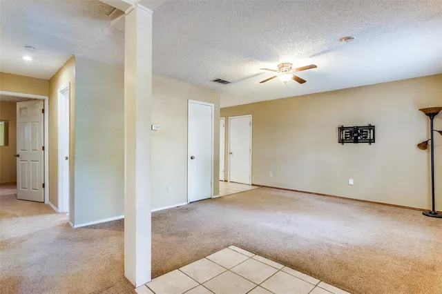 a view of a livingroom with a chandelier fan and windows