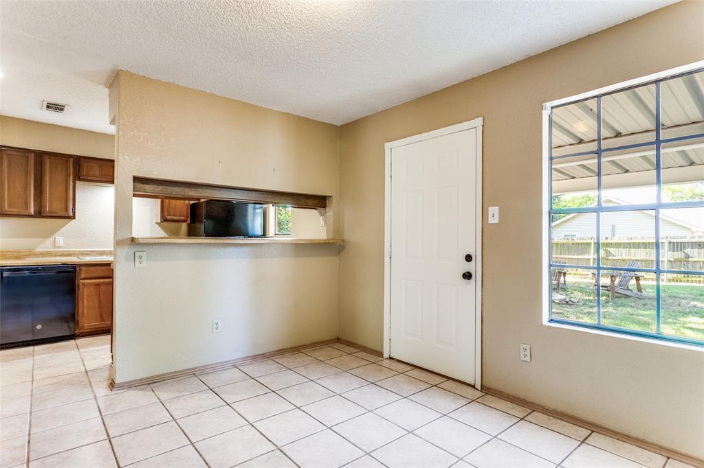 825 Blue Ridge Drive Burleson, TX 76028 - Photo 10 of 25 View of kitchen as seen from breakfast area showcasing view of back yard from window and back yard entrance.