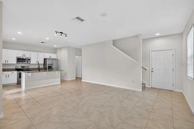 a view of kitchen with refrigerator and microwave