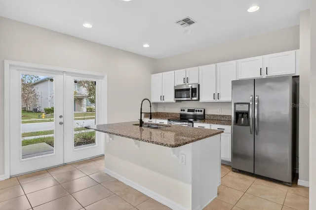 a kitchen with kitchen island a sink stove and refrigerator