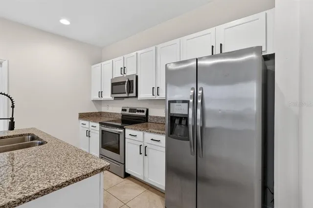 a kitchen with a refrigerator stove and sink