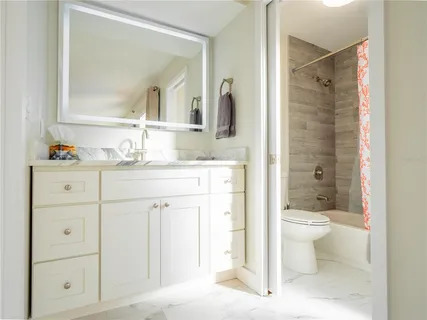 a spacious bathroom with a toilet sink and mirror