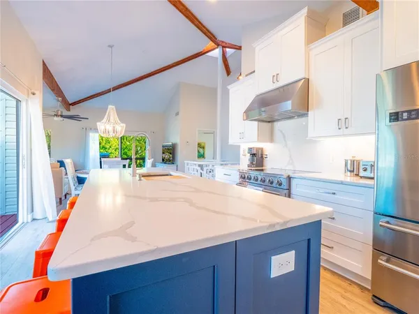 a room with kitchen island a sink and a stove