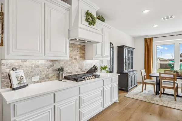 a kitchen with stainless steel appliances white cabinets a stove a sink and a refrigerator